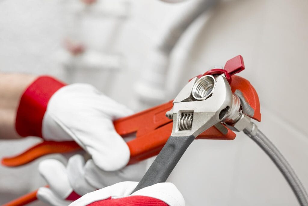 Plumber holding pipe wrenches for an emergency repair in Port Orange