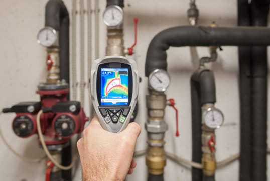 Plumber using a thermal imaging camera to inspect pipes in Port Orange