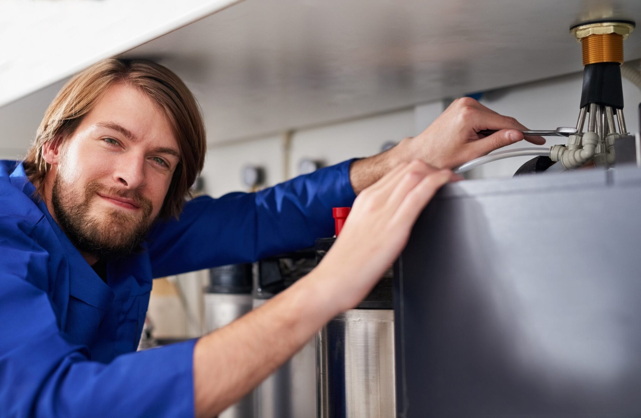 Technician servicing a residential water heater tank in Port Orange