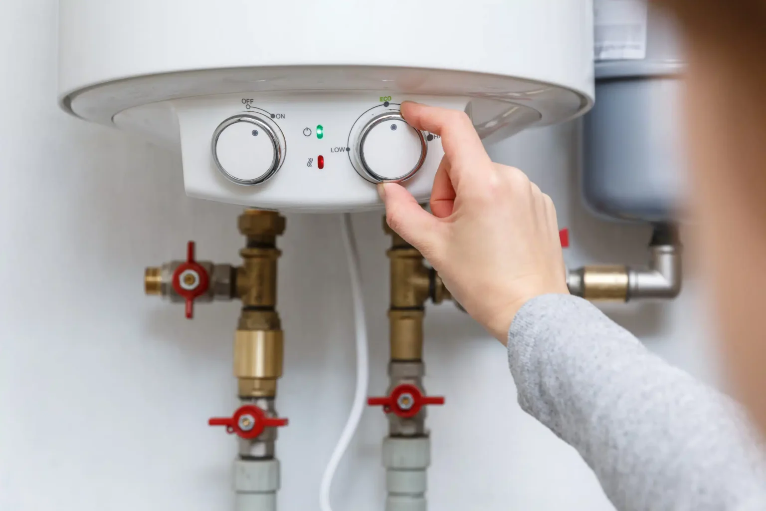 Homeowner adjusting the temperature controls on a water heater in Port Orange